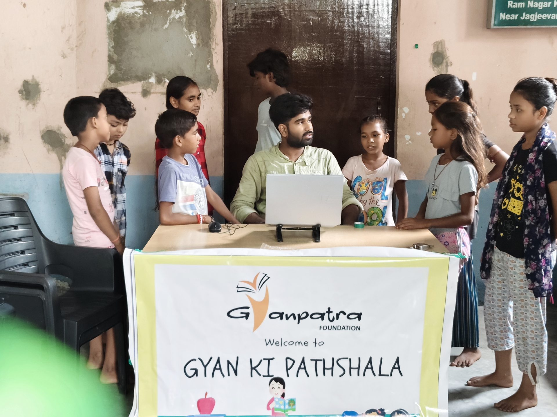 A volunteer teaching with a laptop at the Gyan Ki Pathshala desk