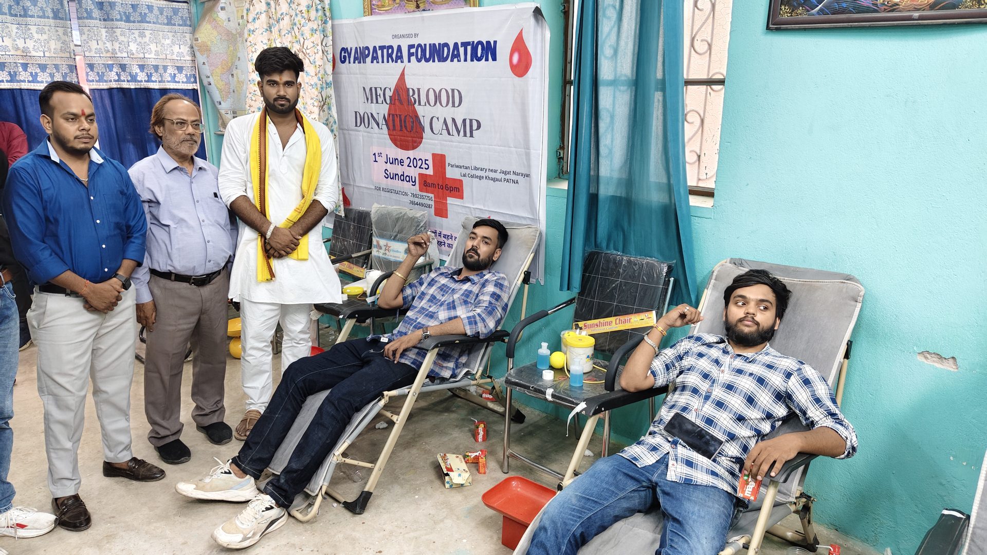 Volunteers and donors at the Mega Blood Donation Camp banner